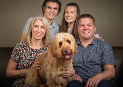 Family sitting with cockapoo dog wirral family photographer