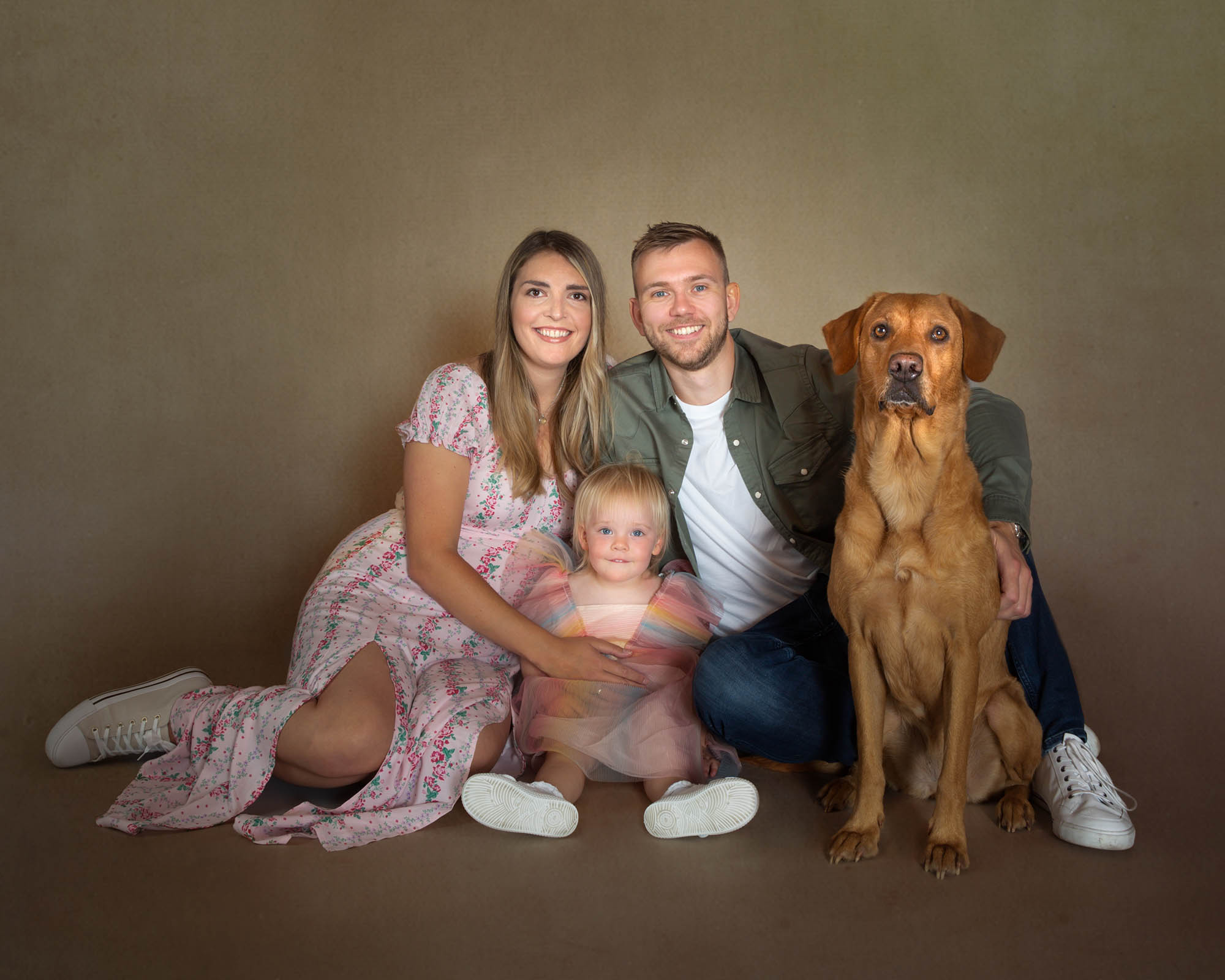 Mum and dad with small child and a cute labrador