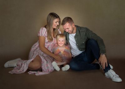 Mum and Dad looking down at smiling baby girl Wirral family photographer