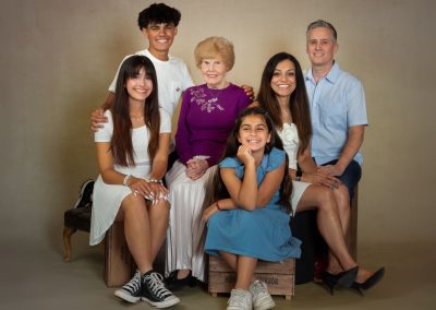 Smiling Grandmother surrounded by her children and grandchildren Wirral Family Photographer