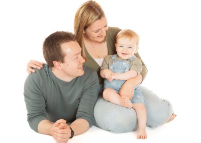 Parents having fun with baby on a white background Wirral family photographer