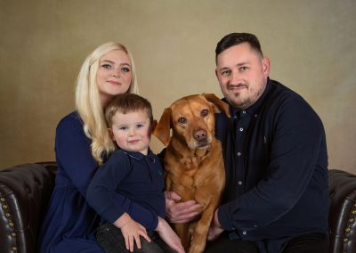 Family with dog sitting on a sofa wirral children's photographer